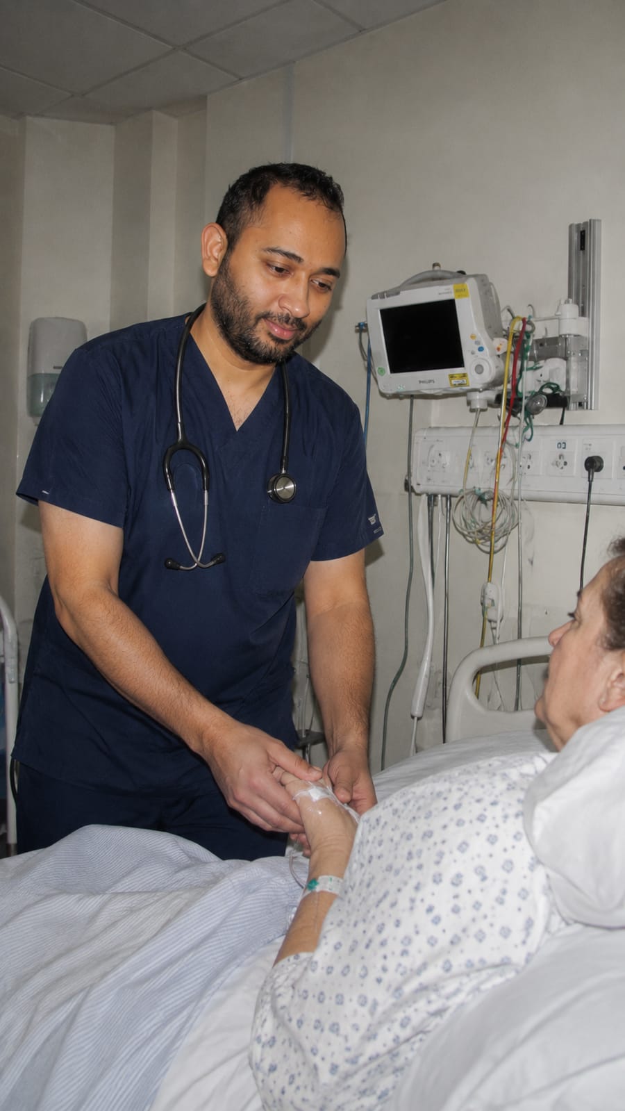 Dr Dinuk at a patient's bedside in hospital